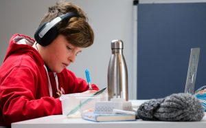dječak piše zadaću uz laptop